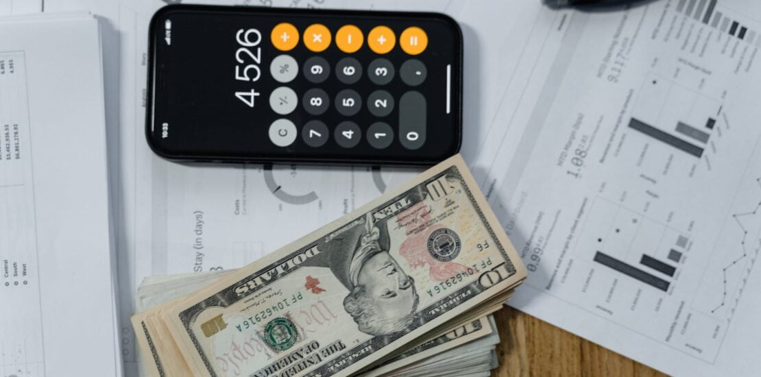 cash money and a calculator on white paper printout