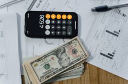 cash money and a calculator on white paper printout