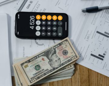 cash money and a calculator on white paper printout